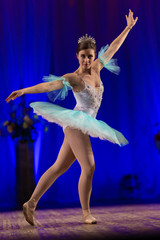 Young girl ballerina in a light blue dress tutu dancing performance of a ballet on stage in a theater © Kozlik_mozlik