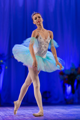Young girl ballerina in a light blue dress tutu dancing performance of a ballet on stage in a theater © Kozlik_mozlik
