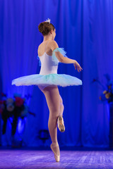 Young girl ballerina in a light blue dress tutu dancing performance of a ballet on stage in a theater © Kozlik_mozlik