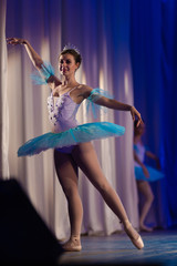 Young girl ballerina in a light blue dress tutu dancing performance of a ballet on stage in a theater © Kozlik_mozlik