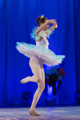 Young girl ballerina in a light blue dress tutu dancing performance of a ballet on stage in a theater © Kozlik_mozlik