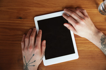 Close up of male hands using tablet with blank screen, copyspace. Surfing, online shopping, scrolling, betting, working. Education, freelance, art and business concept. Watching cinema, reading book.