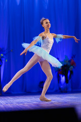 Young girl ballerina in a light blue dress tutu dancing performance of a ballet on stage in a theater © Kozlik_mozlik