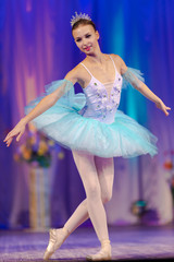 Young girl ballerina in a light blue dress tutu dancing performance of a ballet on stage in a theater © Kozlik_mozlik