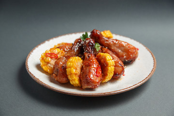 spicy chicken legs sprinkled with sweet corn sauce on a gray background