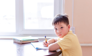 Asian child boy student in medical face mask homework online lesson at home, epidemic Coronavirus, MERS-CoV, 2019-nCoV, quarantine, Covid-19 self-isolation, online education, home schooling