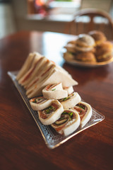 Delicious easter brunch with homemade sandwiches, buns and filled eggs on a wooden kitchen table 