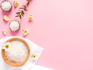 Spa flatlay composition. Sea salt, bath towel, flower, plant on pink background. Copyspace, top view. Home care concept, relax and rest