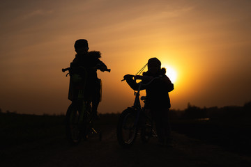 Obraz na płótnie Canvas children on bicycles at sunset