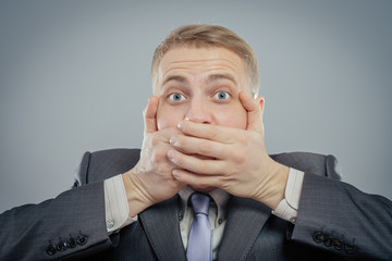 business man making the speak no evil gesture