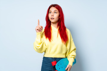 Teenager skater girl isolated on white background thinking an idea pointing the finger up