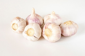 Garlic bulbs and garlic cloves on a white background.
