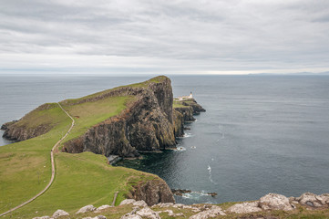 Fototapeta na wymiar Neist Point lighthouse from Neist Cliff viewpoint. Concept: famous natural landscape, Scottish landscape, tranquility and serenity, power of the sea