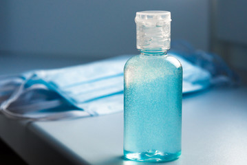 Coronavirus prevention medical surgical mask, hand sanitizer gel bright blue color for hand hygiene and medical disposable pink gloves, corona virus protection. Covid19 virus disinfection concept.