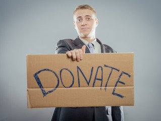 man holding Cardboard text a donate
