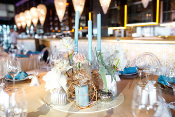 banquet table is decorated with plates, cutlery, glasses, candles and flower arrangements