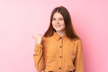 Ukrainian teenager girl over isolated pink background pointing to the side to present a product