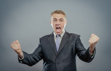Portrait of a energetic young business man enjoying success, screaming