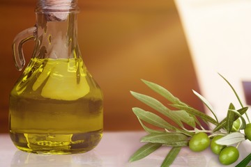 Aroma oil in the jug and olives on the desk