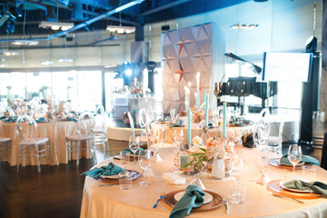 banquet table is decorated with plates, cutlery, glasses, candles and flower arrangements
