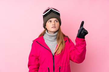Ukrainian teenager skier girl with snowboarding glasses over isolated pink background touching on transparent screen