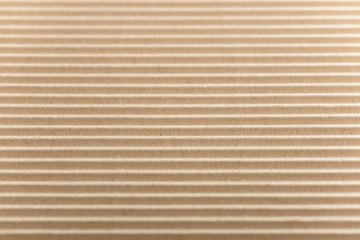Carton or cardboard packing material. Texture of corrugated paper sheets made from cellulose. Supplies for creating boxes and packaging. Pasteboard background. Natural brown cardboard surface.