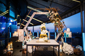 night wedding ceremony, the arch is decorated with flowers, candles and garlands of light bulbs and...