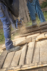 man cutting wood with chainsaw close up