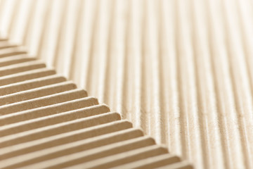 Carton or cardboard packing material. Texture of corrugated paper sheets made from cellulose. Supplies for creating boxes and packaging. Pasteboard background. Natural brown cardboard surface.