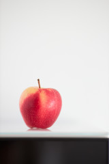 Isolated red apple on white background. Partial black front. Vertical