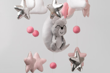 Baby crib mobile - kids toys, on light background.