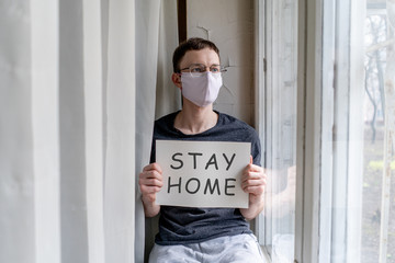 Man sitting on windowsill with nameplate at selfisolation