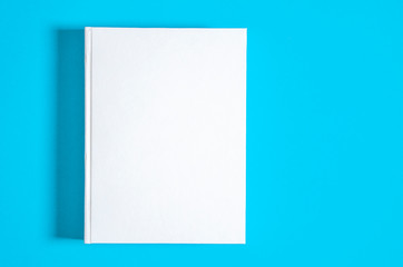 Mockup of closed blank square book at white textured paper