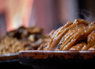 Caramel-colored hot plate of food. Moroccan traditional