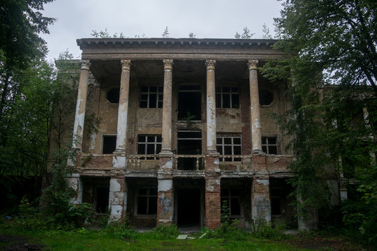 Front view of old abandoned mansion building facade. Vintage historical architecture ruins. Destruction of old building.