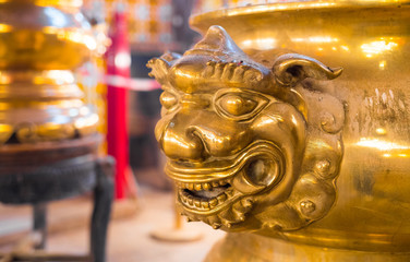 Lion face embbeded onto an incense golden cauldron. Man Mo Temple, Hollywood Road, Hong Kong, China. Beautiful close up