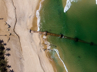 Top down view of waves coming in on the beach of Ipanema where a large pipeline is being exposed after a strong tidal wave washed away a lot of the beach sand