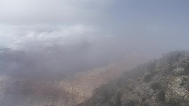 A stunning wide timelapse looking east of clouds flowing inside the Grand Canyon. The canyon is revealed and hidden by the passing cloud.