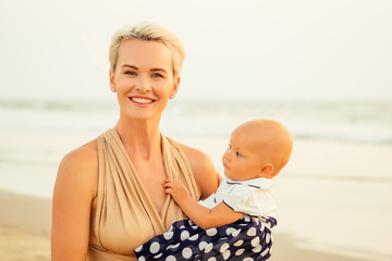breast-feeding on breast-feeding concept. beautiful woman with baby on the summer beach at sunset