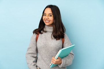 Young mixed race woman going to school isolated on blue background laughing