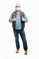 Bald man in a medical mask shows thumbs up. Precautions during the coronavirus pandemic. White background. Vertical.