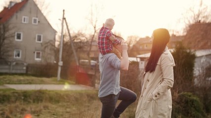 Young family having fun with their little son outdoors