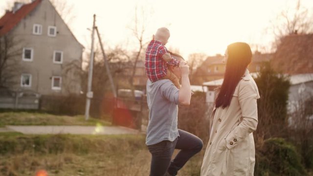 Young family having fun with their little son outdoors