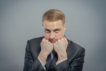 Young businessman thinking with his head on his fists