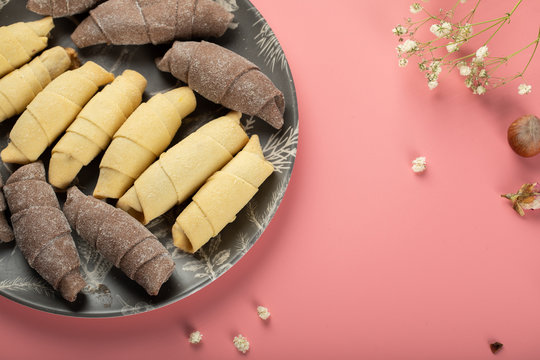 Traditional caucasian sweets mutaki with cocoa dough in a black platter on pink background