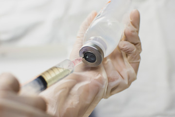 Anesthesiologist Doctors hand inject syringe into normal saline solution (NSS) bottle,Coronavirus...