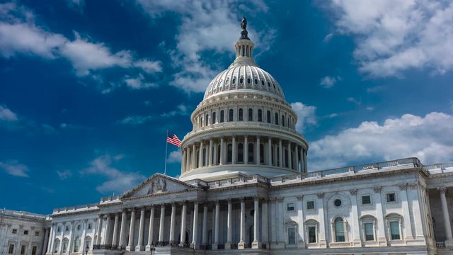 Zooming in to the US Capitol in this time lapse cinemagraph with beautiful blue sky and clouds slowly moving to the right.