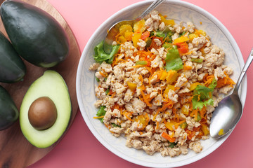 Fresh homemade salad and avocado on pink background 