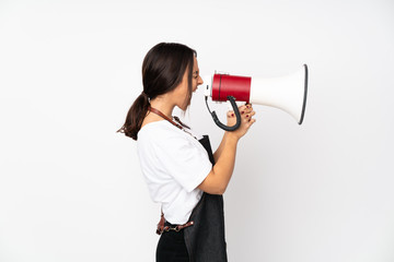 Young hairdresser woman isolated on white background shouting through a megaphone