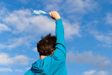 Coronavirus quarantine stop concept. A man takes off a medical mask happy freedom. After Covid-19....